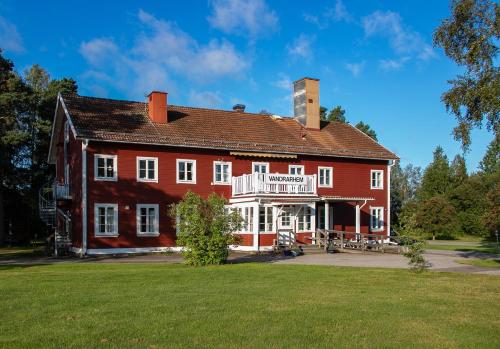 a large red brick building with a sign on it at Borrgården Hostel in Ljusdal