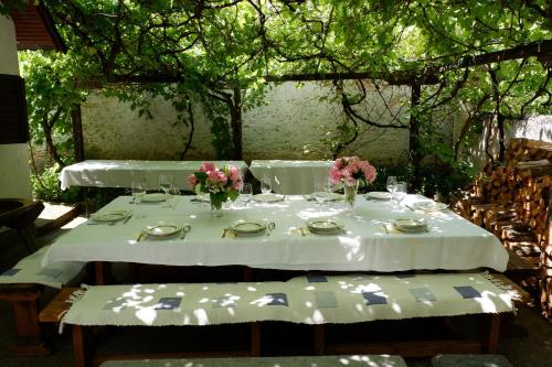 a table with white table cloth and flowers on it at Derű Vendégház és Lovasudvar in Fenyőfő