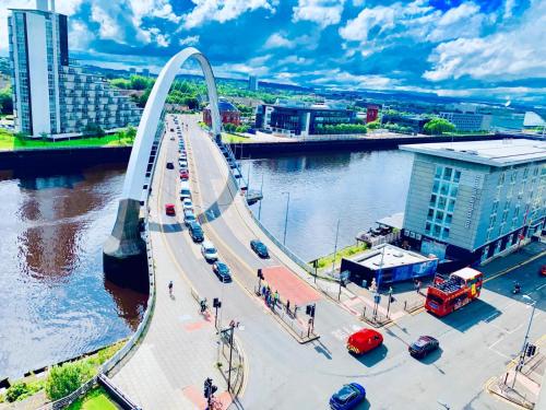 a bridge over a river with cars on it at Glasgow City Centre - The PENTHOUSE with RiverViews - (Duplex, 3 Bedrooms, 3 Bathrooms, 2 Living rooms/Kitchen, Private SKY Terrace, 2 Parkings, Top Floor, Huge - 2100 sq ft, SECC HYDRO) in Glasgow