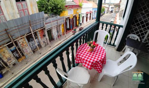 a table and chairs on a balcony with a view of a street at Hostal La Española de Getsemani in Cartagena de Indias