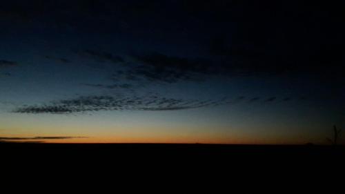 einen Sonnenuntergang auf einem Feld mit wolkigem Himmel in der Unterkunft Ferienhof Schild FeWo Bullerbü in Wangerland