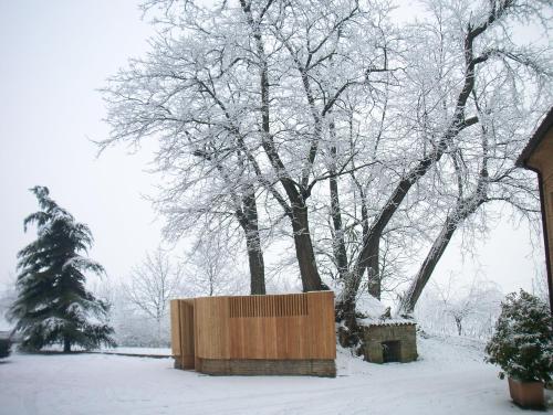 a wooden box in the snow next to a tree at Agriturismo Battibue in Fiorenzuola dʼArda