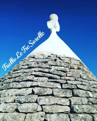 a statue on top of a stone wall at Trullo Le Tre Sorelle in Cisternino