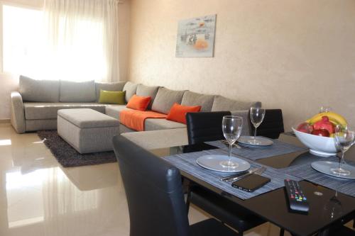 a living room with a table and a couch at Appartement Standing Quartier Tour Hassane (près Marina) in Rabat
