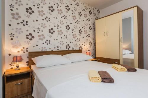 ein Schlafzimmer mit einem Bett mit zwei Handtüchern darauf in der Unterkunft Apartmani Nikola 3 in Trogir