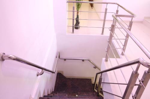 a staircase with metal railings and stairs with a vase at Hotel Apple Inn in Navi Mumbai