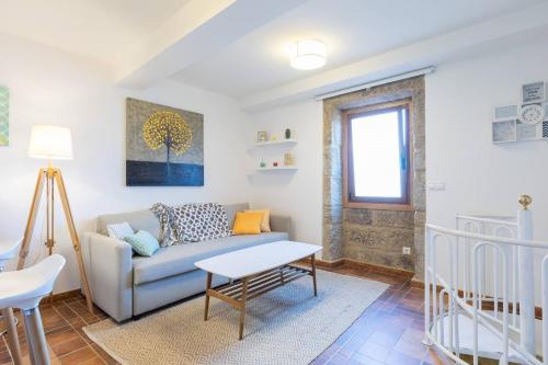 a living room with a couch and a table at Casa Angelita terraza con hórreo y barbacoa in Poio