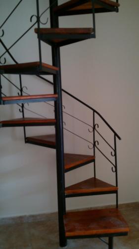 a metal spiral staircase with wooden shelves at Atlantis Park in Mar de Ajó