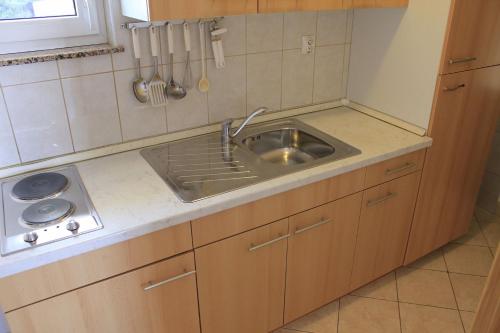 een kleine keuken met een wastafel en een fornuis bij Apartments Zdenka-10m from beach in Vodice