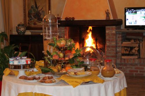 a table with food on it with a fireplace at Hotel De La Ville in Bereguardo