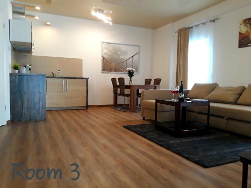 - un salon avec un canapé et une table dans l'établissement Modernes Apartment Metzingen, à Mittelstadt
