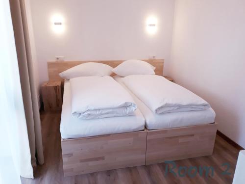 uma cama com duas almofadas brancas em cima em Modernes Apartment Metzingen em Mittelstadt
