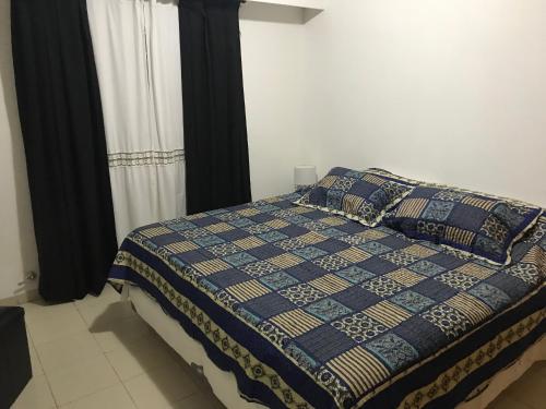 a bedroom with a bed with a quilt on it at Alonso 540 Departamento in Río Cuarto