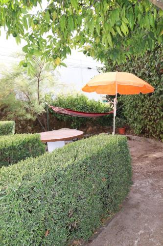 an orange umbrella sitting next to a picnic table at Casa de Mello in Melo