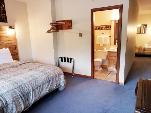 a bedroom with a bed and a bathroom with a mirror at North Ironwood Acres - Black River Lodge in Ironwood
