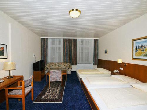 ハンブルクにあるホテル ベイ デル エスプラナーデのベッド2台とデスクが備わるホテルルームです。