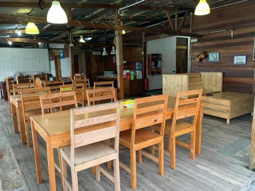 Spheredivers Scuba & Leisure في Pulau Mabul : غرفة طعام مع طاولات وكراسي خشبية