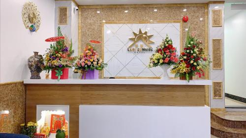 eine Darstellung von Blumen in Vasen auf einem Tresen in der Unterkunft Lagi Sunrise Hotel in La Gi