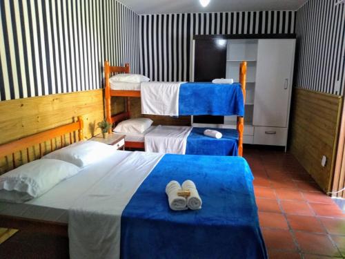 um quarto com duas camas e dois pares de sapatos em Pousada da Lagoa em Florianópolis