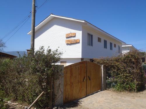 a white house with a wooden fence in front of it at Rapallo´s Los Molles in Los Molles