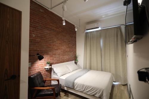 a bedroom with a bed and a brick wall at Dongshan Yi Hostel in Dongshan