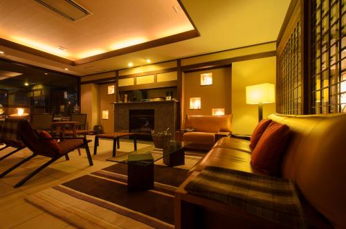 a living room with a couch and a fireplace at Aburaya Tousen in Yamanouchi