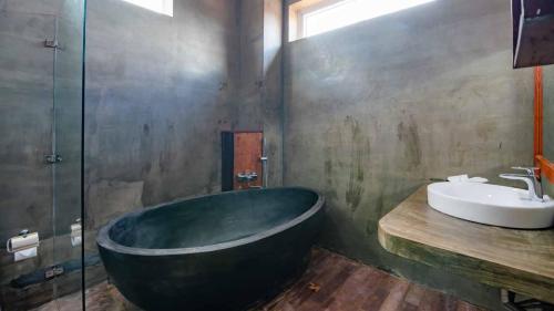 a bathroom with a large bath tub and a sink at Mango Kesararam in Siem Reap