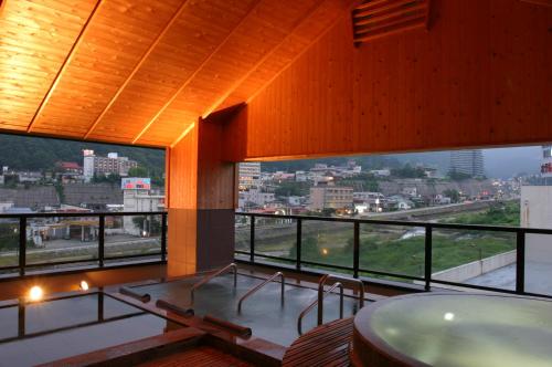 a room with a balcony with a view of a city at Aburaya Tousen in Yamanouchi