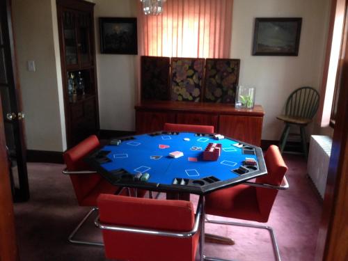 a room with a table with red chairs and a blue at Jacaranda in Milton