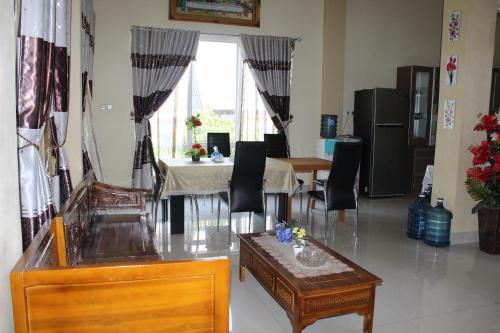 a living room with a table and chairs and a window at Angela Homestay Manado in Tateli