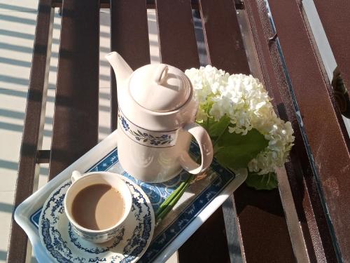 a tray with a cup of coffee and a bouquet of flowers at Rumah Tamu Azizah in Kampong Tanjong Bayan