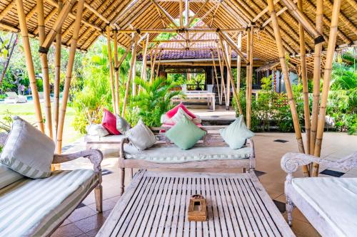 a group of chairs and tables on a patio at Taman Selini Wahana Beach Resort in Pemuteran