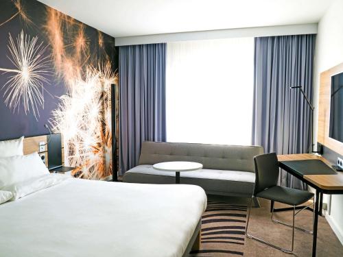 a hotel room with a bed and a couch at Novotel Katowice Centrum in Katowice