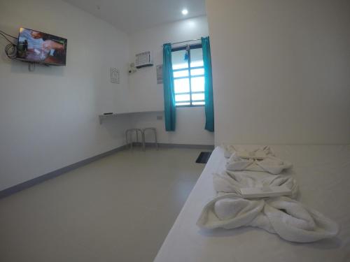 - une chambre blanche avec des serviettes à l'étage dans l'établissement Bulusan Tourist Inn, à Bulusan