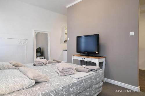 a hotel room with a bed, television and a desk at Downtown Apartment / Free Parking in Ljubljana