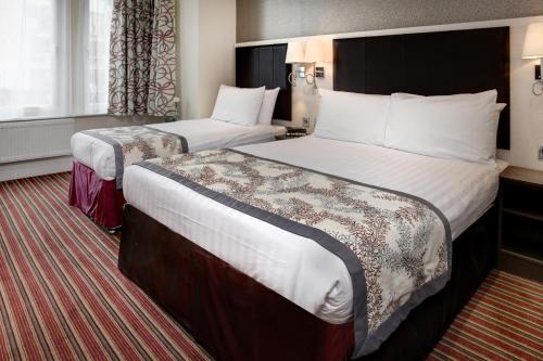 a hotel room with two beds in a room at Best Western Chiswick Palace & Suites London in London