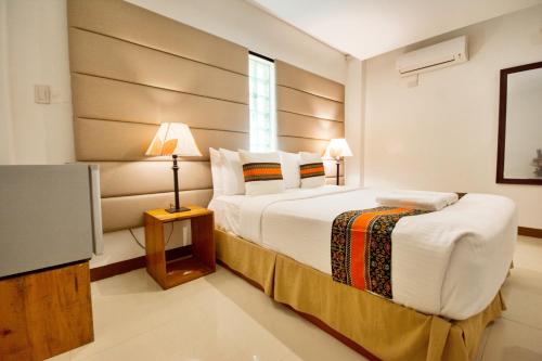 a bedroom with a large bed and a television at Sur Beach Resort Boracay in Boracay