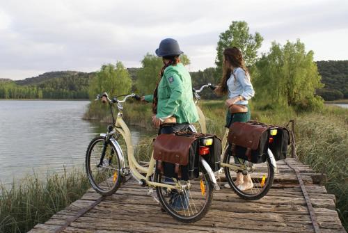 two girls riding bikes on a bridge over a lake at Doña Ruidera in Ruidera