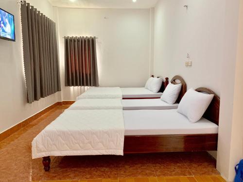 three beds in a room with white walls at PHUC LONG 2 HOTEL in Can Tho