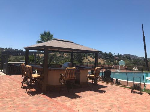 a bar with chairs and an umbrella next to a pool at paradise luxury experience in Woodland Hills