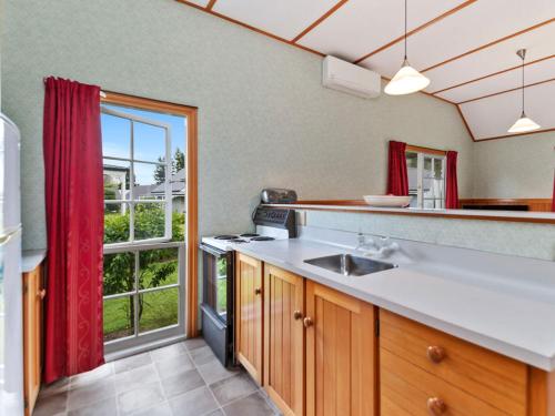 a kitchen with a sink and a large window at Wonderful 2BR Cottage Nr Huka Falls w Aircons in Taupo