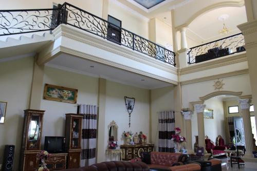 a large living room with a balcony and furniture at Angela Homestay Manado in Tateli