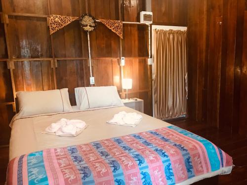 a bedroom with a bed with towels on it at Songthai Suvarnabhumi in Ban Khlong Si