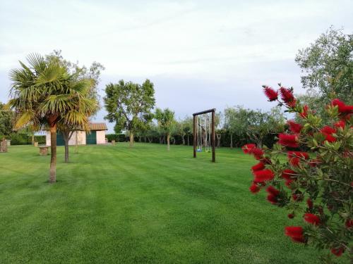 a park with a swing set in the grass at Agriturismo Bocci in Castiglione della Pescaia