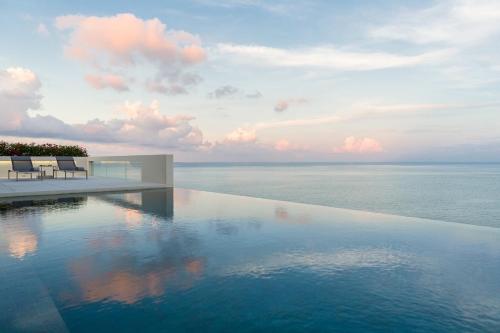 a swimming pool with a view of the ocean at Villa Natha in Choeng Mon Beach