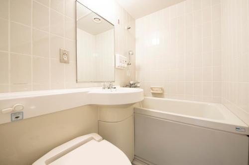 een badkamer met een wastafel, een toilet en een bad bij Maple Inn Makuhari in Chiba