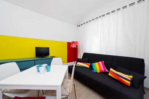 a living room with a black couch with colorful pillows at Budget Apartment in Prague