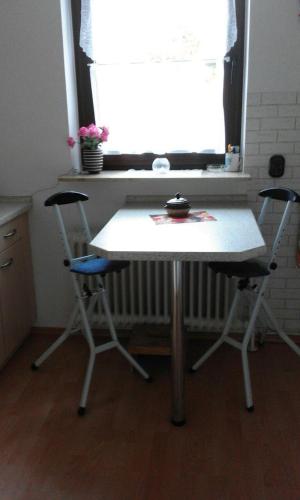 a table and two chairs in a kitchen with a window at Wikingerstadt 1 in Schleswig