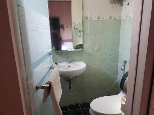 y baño con lavabo, aseo y espejo. en Peye Guesthouse en Malang