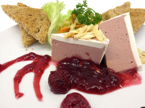 a white plate with a piece of food with raspberry sauce at pension N.10 in Frymburk